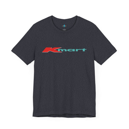 The Printify KMart Logo 1980s Retro - Unisex Jersey Short Sleeve Tee in dark gray features a nostalgic design with the iconic logo in red and teal across the chest. This short-sleeve crew-neck shirt exudes vintage charm with its simple, classic look.