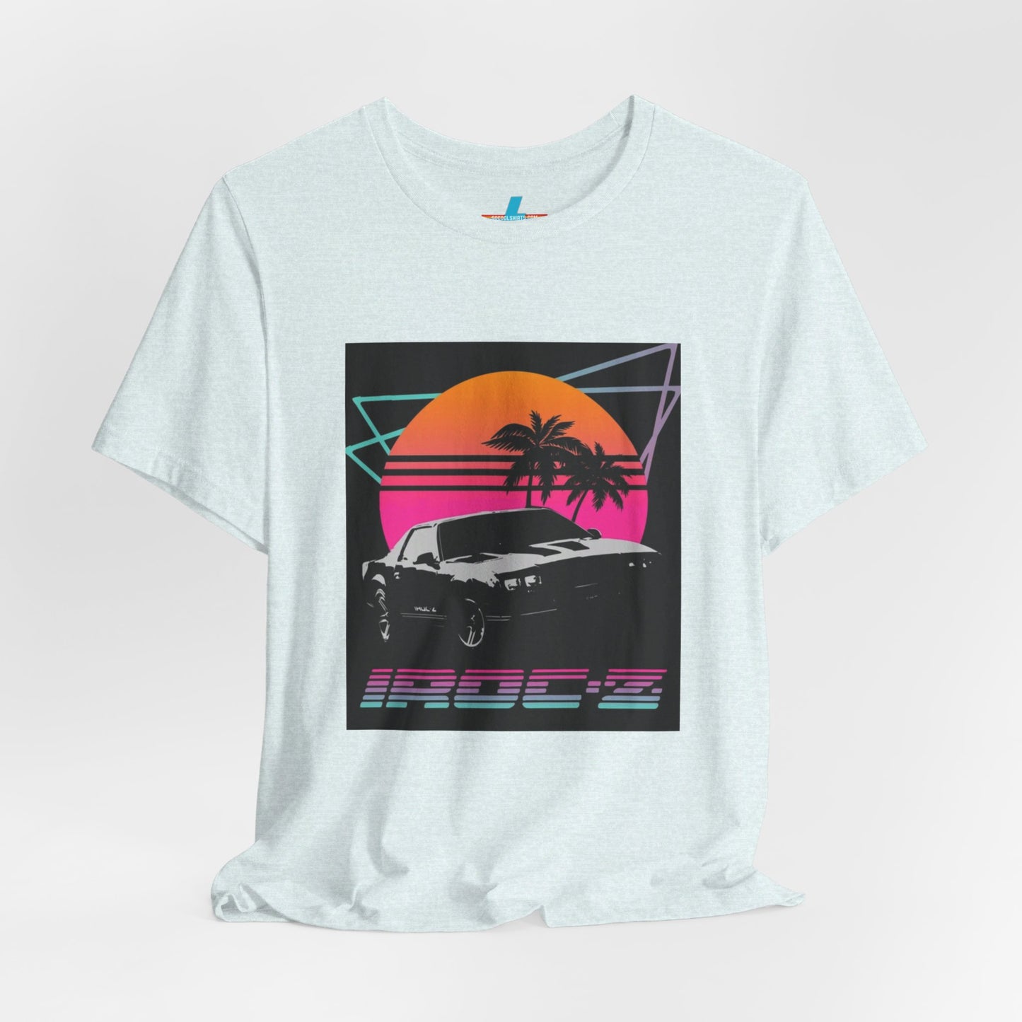 A Chevrolet Camaro iRoc Z Z28 T-Shirt 1980's by Printify, featuring a retro design with a black car, palm trees, and a sun setting in the background. The design includes geometric lines in neon colors and the text "IROC-Z" at the bottom, perfect for fans of the 1980s Chevy Camaro.