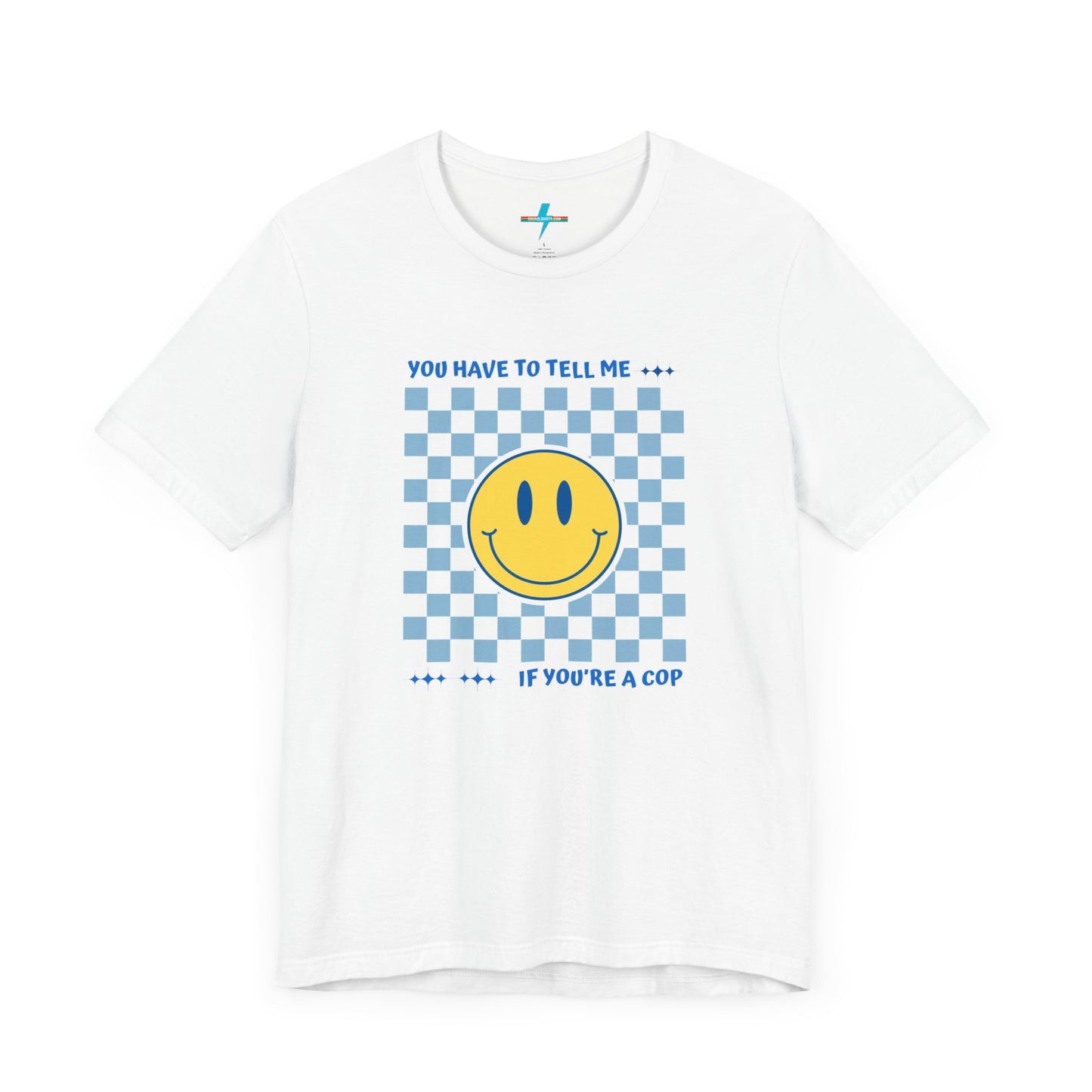 A light yellow unisex jersey short sleeve tee from Printify featuring a blue and yellow checkerboard pattern with a large yellow smiley face in the center. The shirt displays blue text above and below the pattern that reads, "You have to tell me if you're a cop." It's made from 100% Airlume combed and ring-spun cotton.