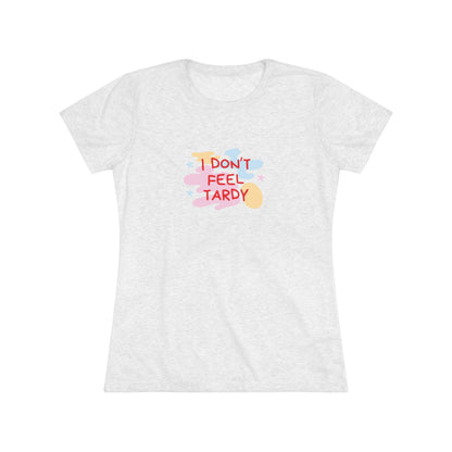 A light gray, short-sleeved Women's Triblend Tee from Printify with the playful phrase "I DON'T FEEL TARDY" printed in colorful letters on the front. The text is surrounded by abstract pastel shapes, giving it retro vibes and a vintage look reminiscent of a Van Halen T-shirt.