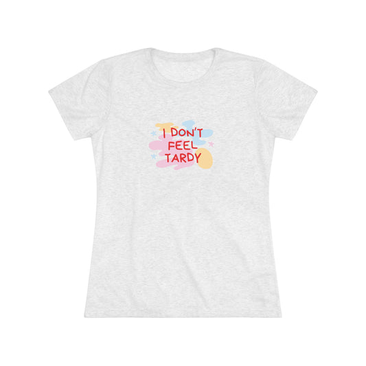 A light gray, short-sleeved Women's Triblend Tee from Printify with the playful phrase "I DON'T FEEL TARDY" printed in colorful letters on the front. The text is surrounded by abstract pastel shapes, giving it retro vibes and a vintage look reminiscent of a Van Halen T-shirt.