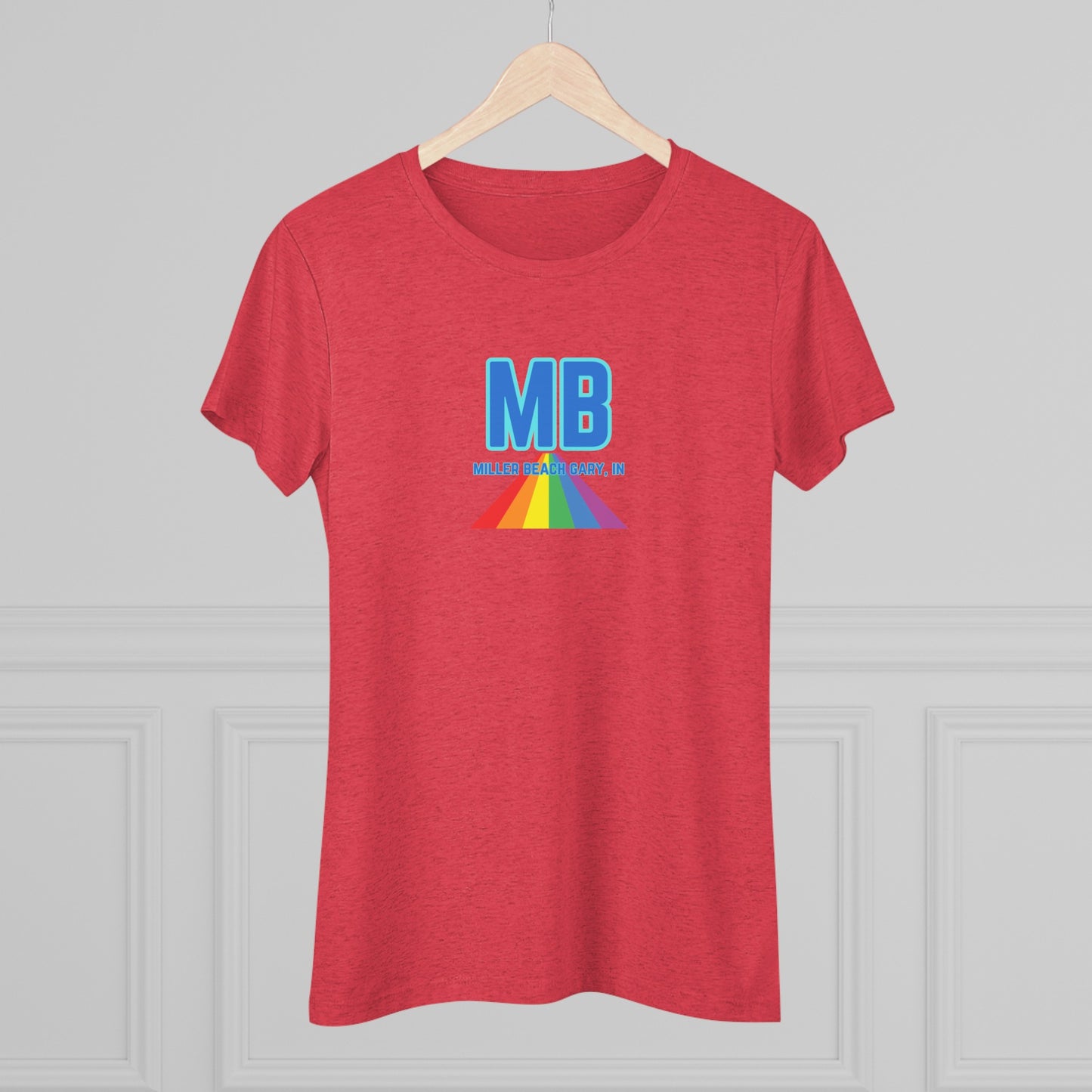 The Miller Beach Pride - Women's Triblend Tee by Printify is a dark gray, cozy t-shirt with a vintage look, featuring the text "MB" in large blue letters at the center. Below the letters, there is a rainbow-colored triangular design with "Millions & Binary, Inc." written in smaller text under the rainbow triangle.