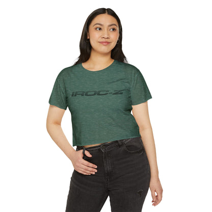 A grey, short-sleeve, rounded-neckline Women's Festival Crop Top by Printify, featuring "IROC-Z" printed in bold black letters across the chest. Perfect for any festival, this Chevrolet Iroc Z-inspired top from the 1980s stands out against a plain white background.