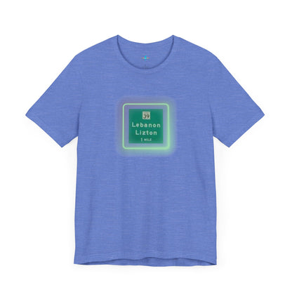 Introducing "The Lebanon Loop - Indiana" unisex jersey short sleeve tee by Printify. This green t-shirt features a graphic of a road sign displaying "39 Lebanon Lizton 1 MILE" within a slightly glowing square frame. It's crafted from 100% Airlume cotton and photographed flat on a white background.