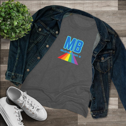 The Miller Beach Pride - Women's Triblend Tee by Printify is a dark gray, cozy t-shirt with a vintage look, featuring the text "MB" in large blue letters at the center. Below the letters, there is a rainbow-colored triangular design with "Millions & Binary, Inc." written in smaller text under the rainbow triangle.