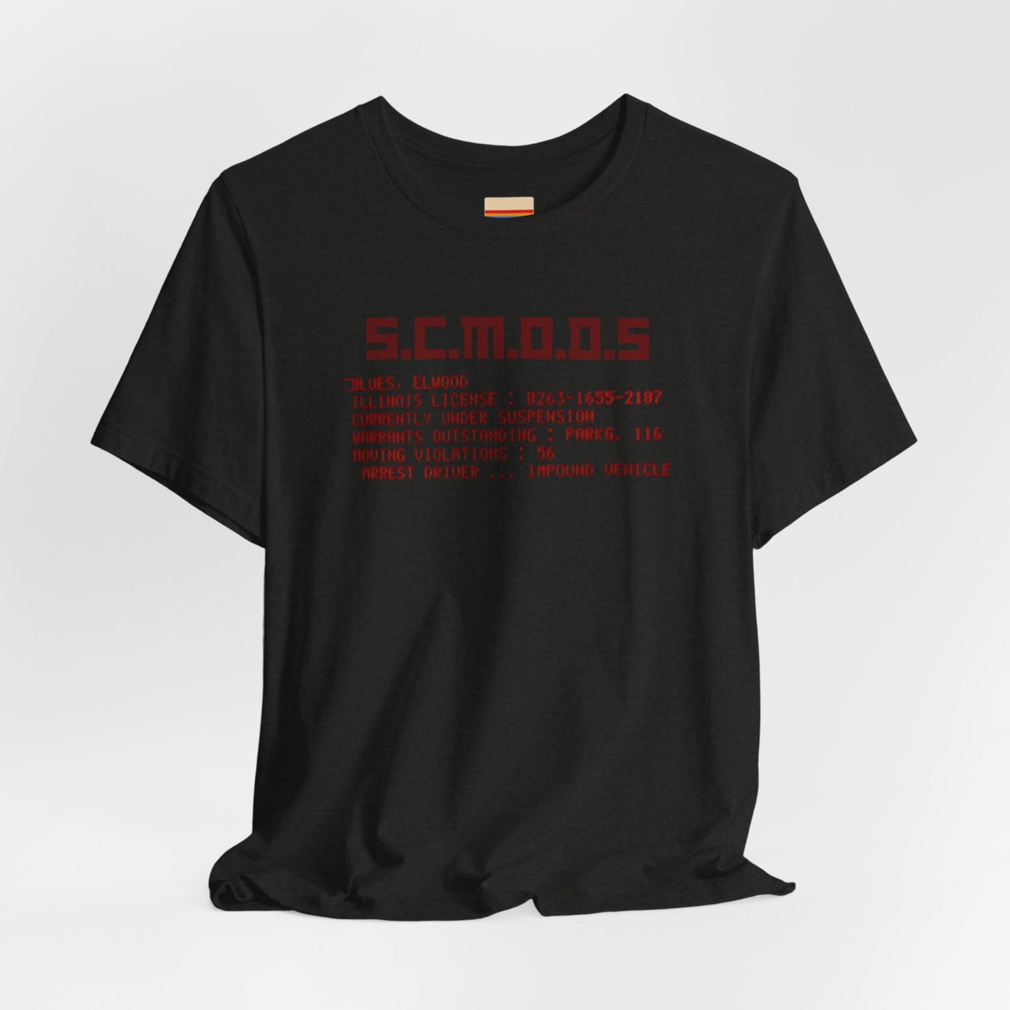 Two yellow "S.C.M.O.D.S. Blues Brother's - Unisex Jersey Short Sleeve Tee" shirts from Printify, featuring "S.C.M.O.D.S" in bold, stylized letters along with smaller text detailing terms like "Illinois," "license," and "impound vehicle." Perfect for fans of The Blues Brothers and Jake and Elwood Blues, the T-shirts are neatly folded and stacked.