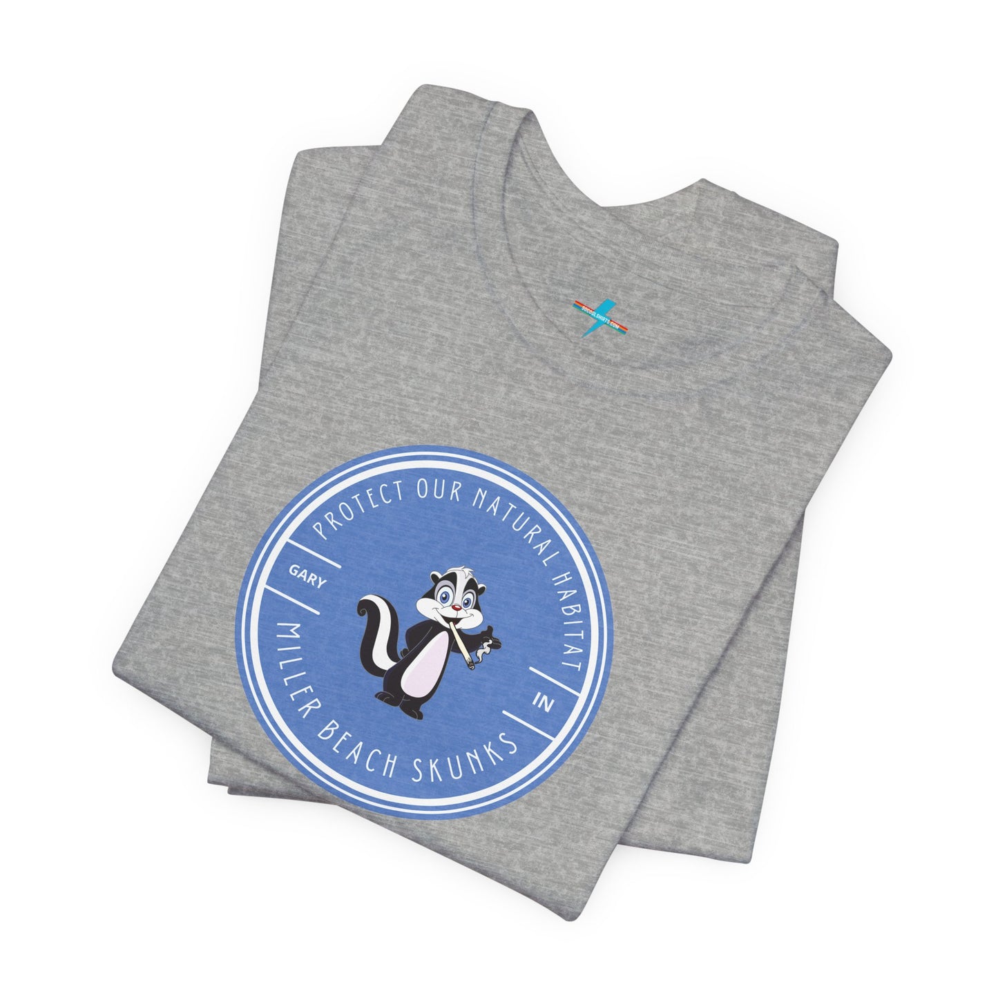 The Printify Miller Beach Skunks - Unisex Jersey Short Sleeve Tee is a gray T-shirt that features a circular blue logo at the center. Inside the logo, there is an illustration of a skunk with the text "Protect Our Habitat" and "Miller Beach Skunks" around the border, promoting environmental consciousness. The upper left part of the logo reads "Gary, IN.