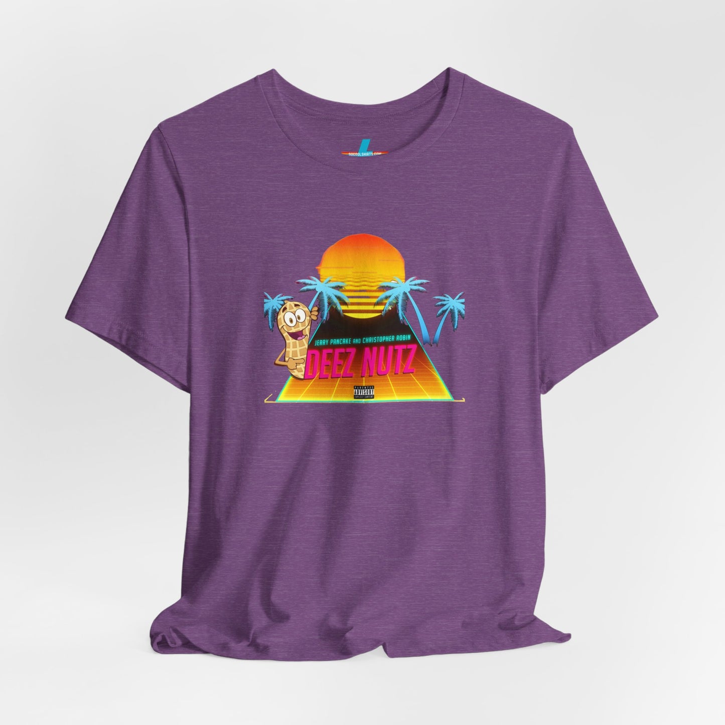 A Printify "Deez Nutz Jerry Pancake and Christopher Robin" t-shirt in purple, featuring a graphic of a sunset over a pyramid with palm trees and an illustration of an anthropomorphic nut holding a sign. The text on the shirt reads, "Just hanging out, cracking open... DEEZ NUTZ." Perfect as a unisex jersey short sleeve tee!