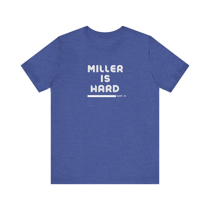 The Miller is Hard - White Letters - Unisex Jersey Short Sleeve Tee by Printify features a rust-colored design with "MILLER IS HARD" printed in bold, white capitals on the front. Below, "GARY, IN." is added in smaller font. This simple yet striking shirt evokes the spirit of Miller Beach with no additional graphics or patterns.