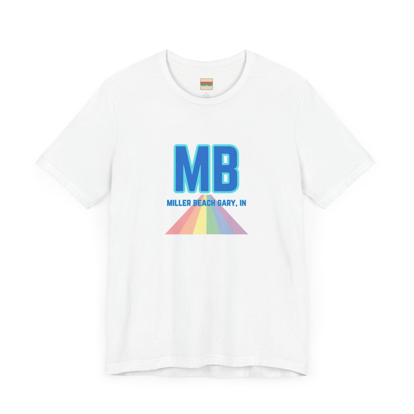 The Miller Beach Pride - Unisex Jersey Short Sleeve Tee by Printify is a white shirt made from 100% Airlume combed cotton. It showcases a design with large, bold blue letters "MB" at the top. Beneath it, the text "MILLER BEACH GARY, IN" is written in blue. A colorful, triangular rainbow graphic extends downward from the text, symbolizing Miller Beach pride.