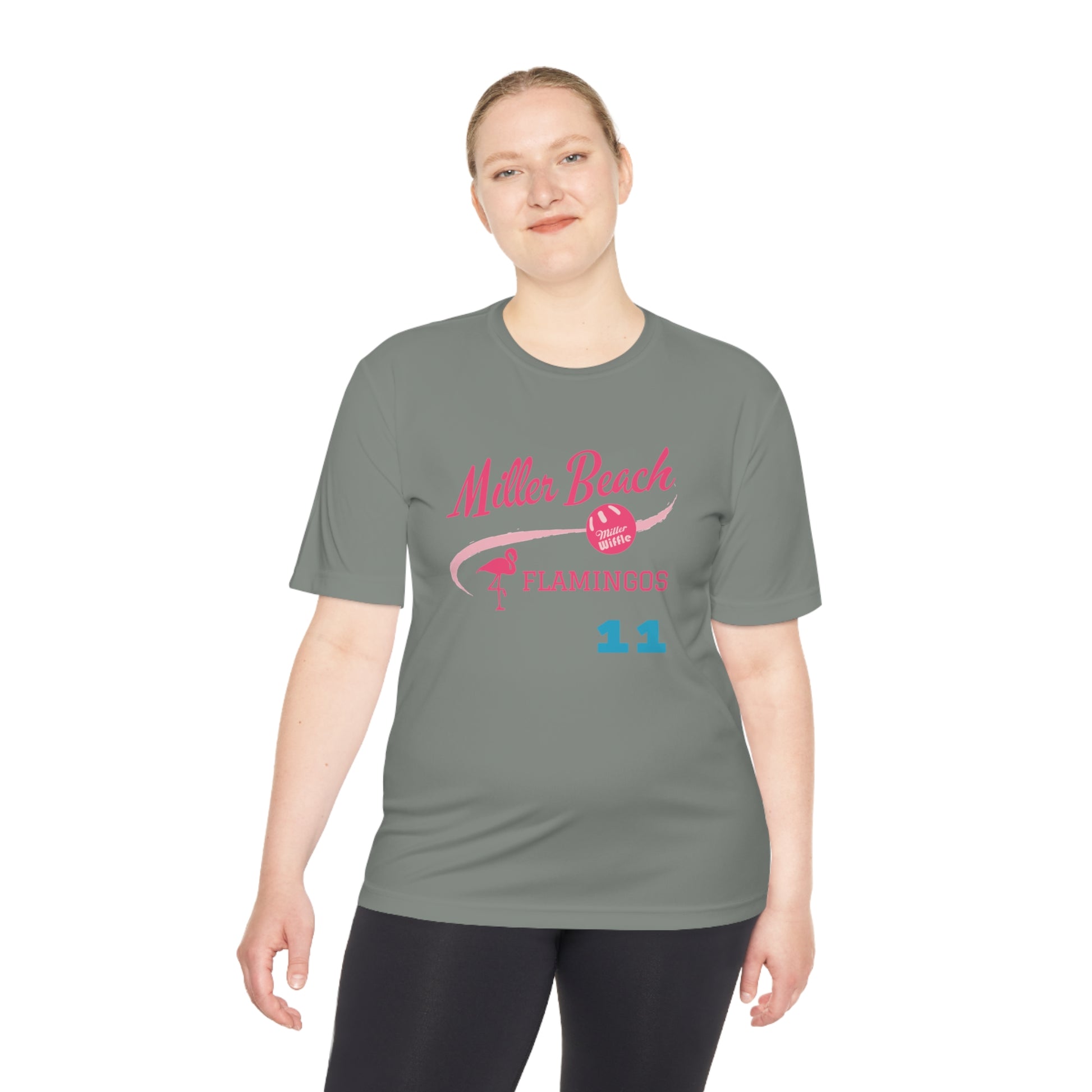 The Miller Beach Flamingos - Poncin 11 Unisex Moisture Wicking Tee by Printify features a beige shirt with "Miller Beach" in pink script, accompanied by a small illustration of a flamingo and volleyball. Below this design, the word "FLAMINGOS" is displayed in pink, with the number "11" appearing in blue near the bottom. Made from Sport-Tek PosiCharge Competitor Tee fabric, this custom moisture-wicking shirt ensures you stay cool and stylish.