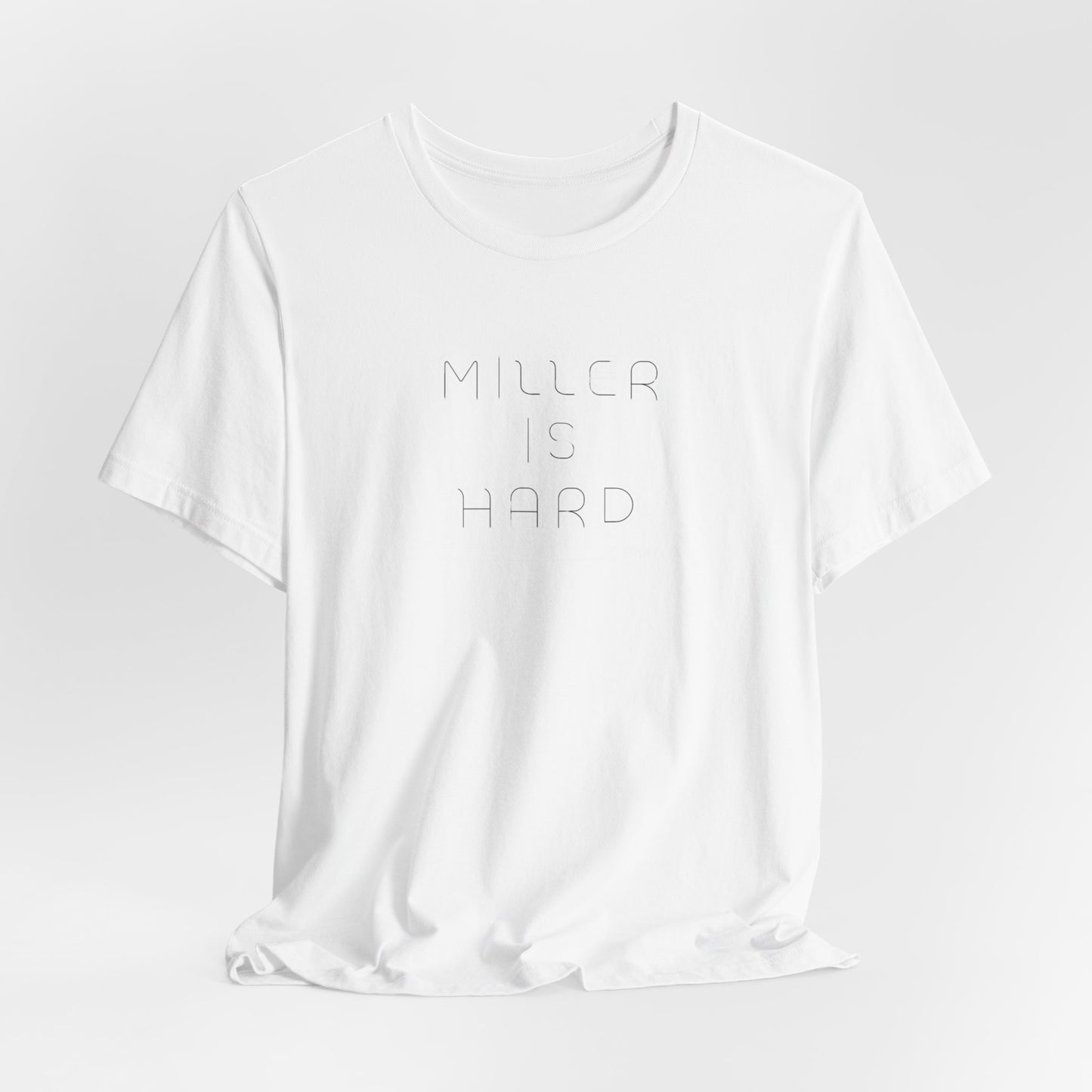 The Miller is Hard - White Letters - Unisex Jersey Short Sleeve Tee by Printify features a rust-colored design with "MILLER IS HARD" printed in bold, white capitals on the front. Below, "GARY, IN." is added in smaller font. This simple yet striking shirt evokes the spirit of Miller Beach with no additional graphics or patterns.