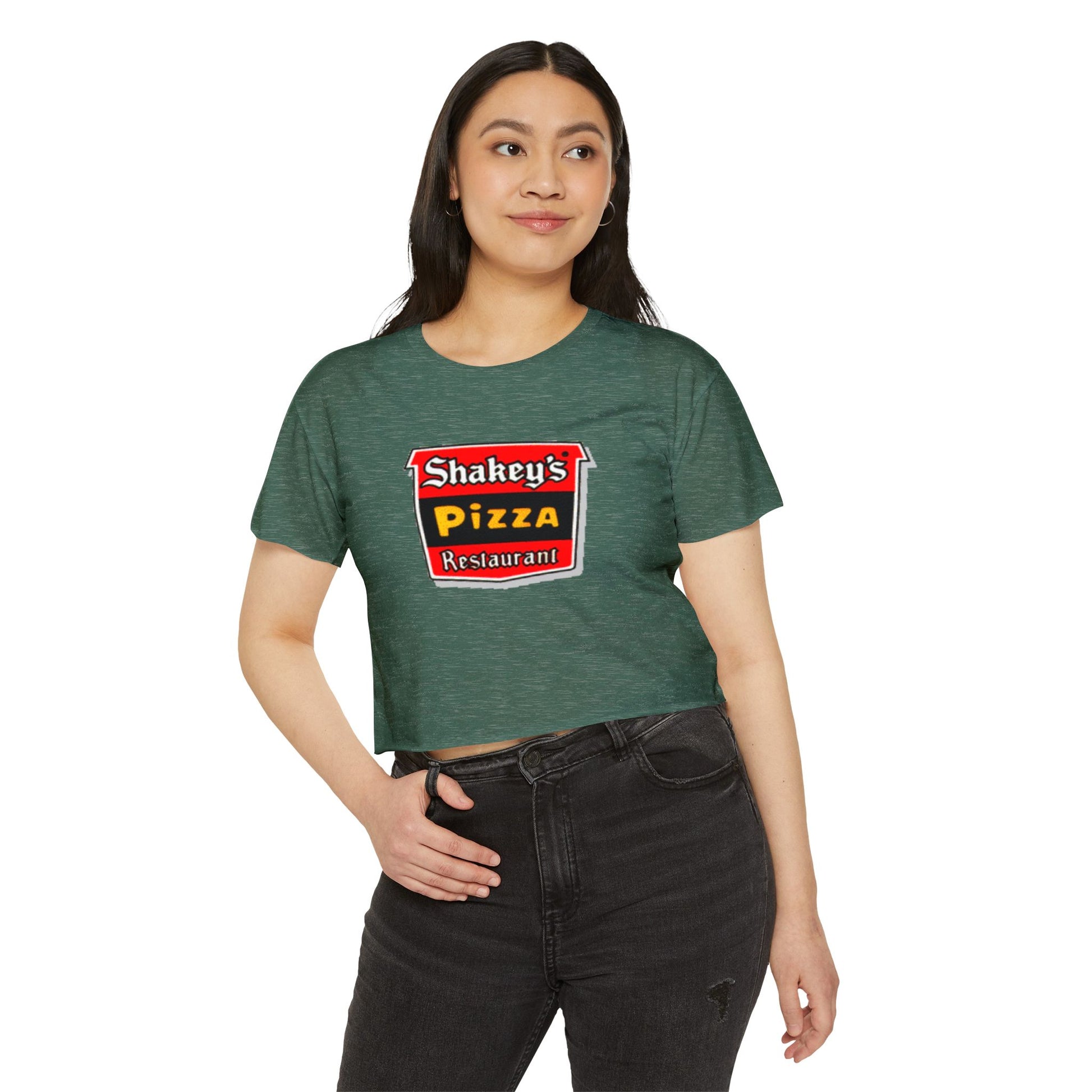 The Shakey's Pizza - Women's Festival Crop Top from Printify is a light blue garment that proudly displays the iconic Shakey's Pizza logo on the chest. Featuring retro-style red and black signage with text in white, yellow, and red that reads "Shakey's Pizza Restaurant," this crop top exudes a vintage-inspired charm.