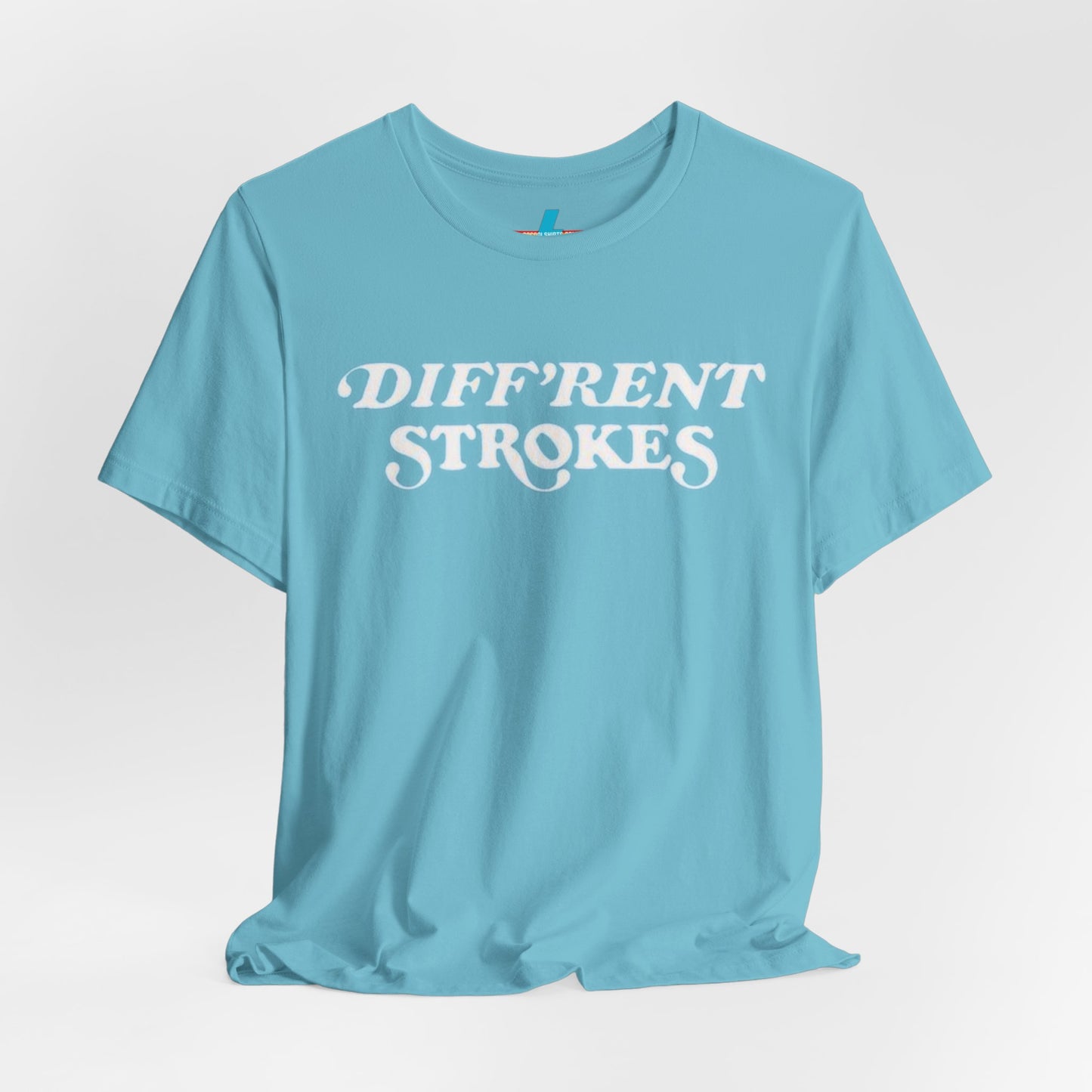 A burnt orange "Diff’Rent Strokes - Retro 1980s" unisex jersey short sleeve tee by Printify, featuring the phrase "DIFF'RENT STROKES" in bold, white cursive letters across the chest. The plain white backdrop perfectly showcases this nostalgic TV apparel.