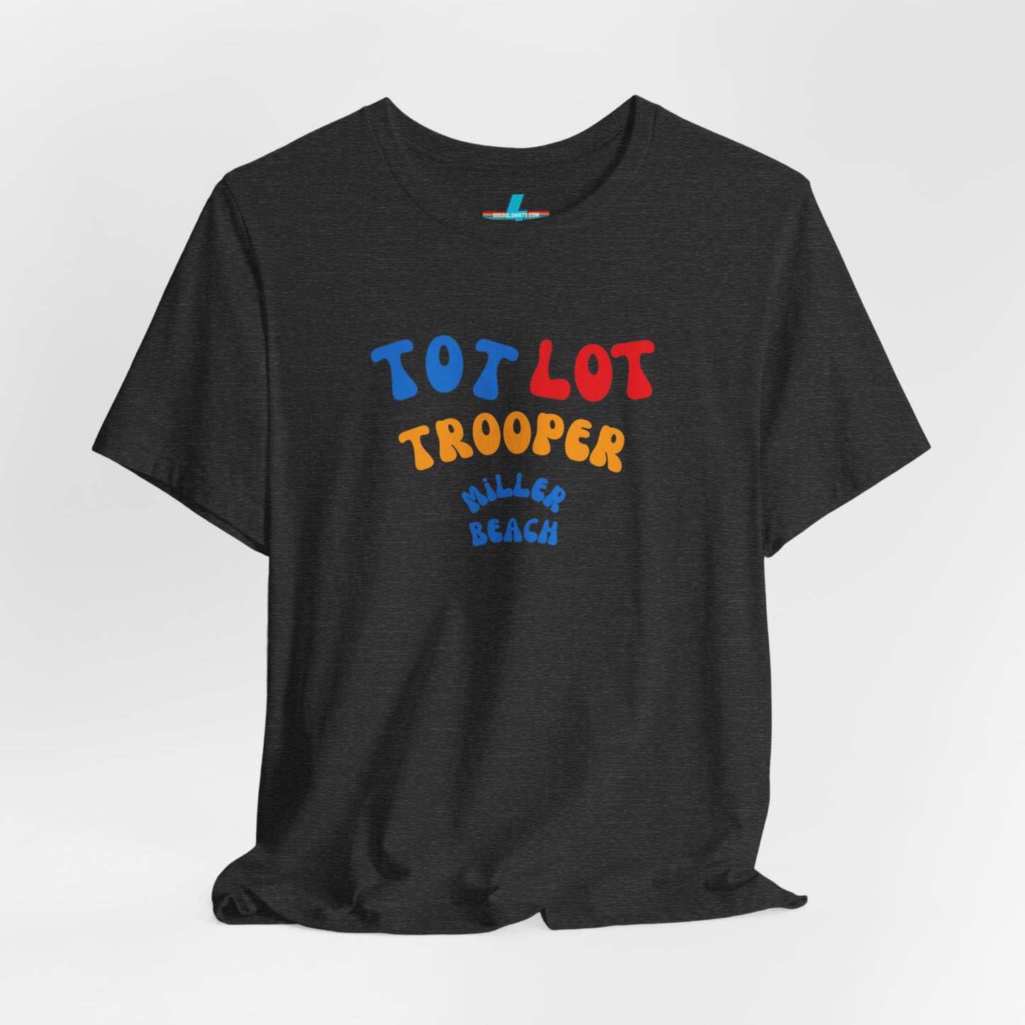 A green unisex jersey short sleeve tee from Printify, featuring colorful text on the front that reads "TOT LOT TROOPER MILLER BEACH" in blue, red, yellow, and orange letters. The shirt is displayed against a plain white background.