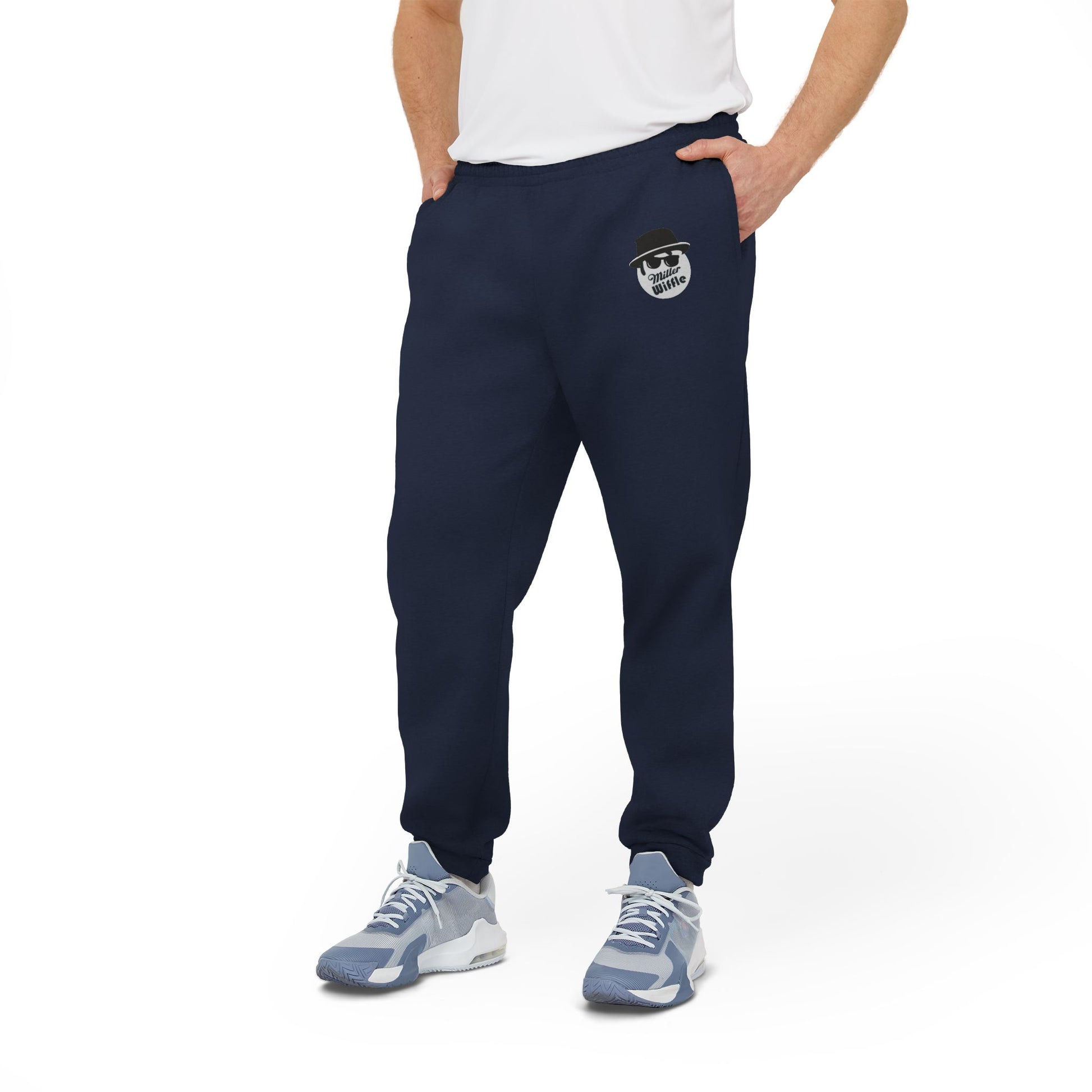 Introducing the Printify Miller Beach Wiffel Ball Blues Brothers Adidas Unisex Fleece Joggers: stylish gray sweatpants adorned with the iconic Adidas logo and a unique design of a stylized face wearing sunglasses and a hat on the left leg, crafted from sustainable materials under the Better Cotton Initiative.