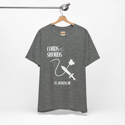 The SoCool Podcast - Cords & Swords Store T-Shirt by Printify is a vintage-inspired blue shirt that showcases a white graphic with the text "Cords & Swords" above illustrations of a crossed power cord and sword, along with "St. Joseph, MI" beneath. Ideal for tech enthusiasts, this design is centered on the front against a plain white background.