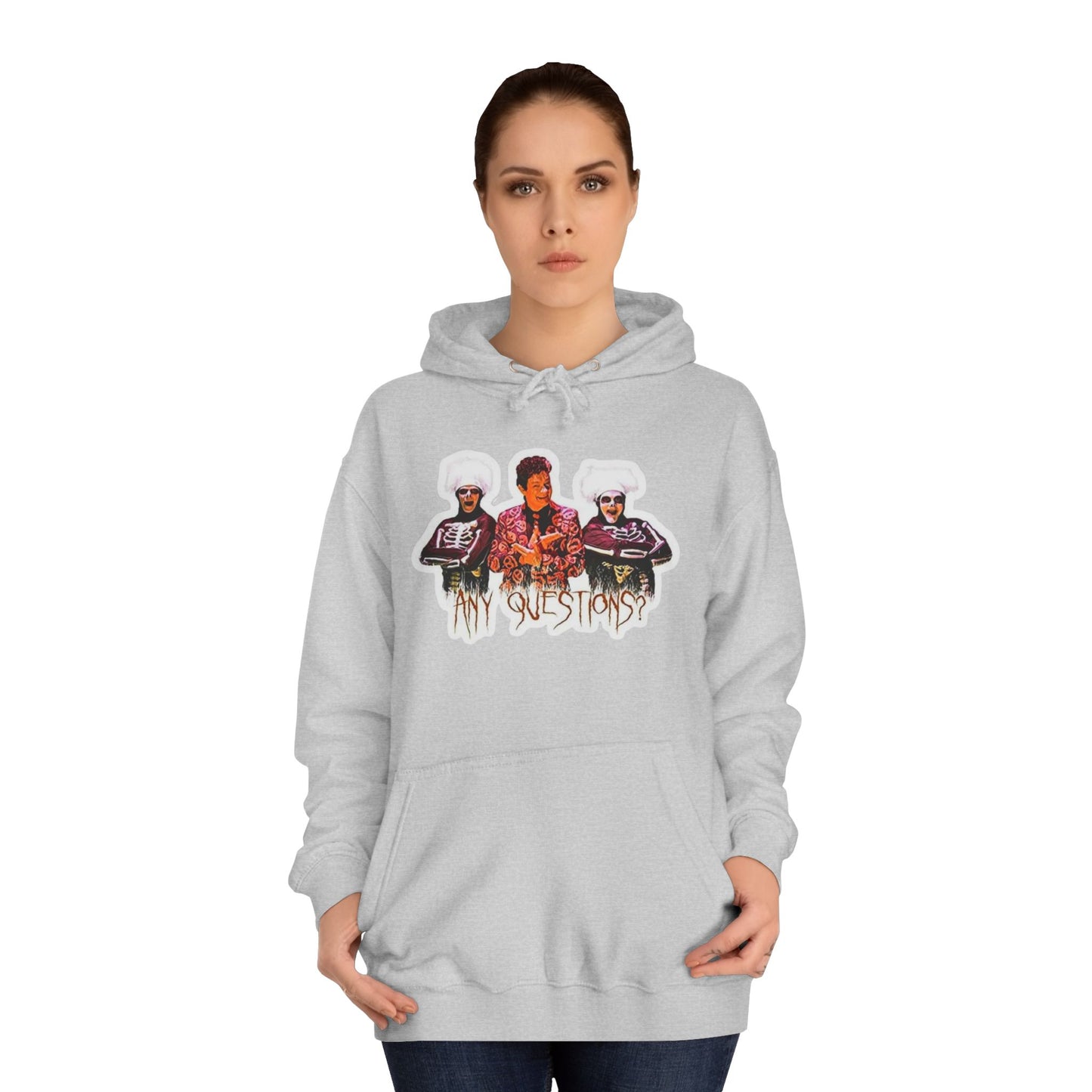 The David S Pumpkins - Any Questions? - Halloween Unisex College Hoodie by Printify is a brown sweatshirt showcasing an illustration of three people. The central figure has red hair, sports a colorful ensemble, and emanates a Halloween vibe, with two flanking figures who have white hair and wear dark attire. Beneath the trio is the phrase "Any Questions?