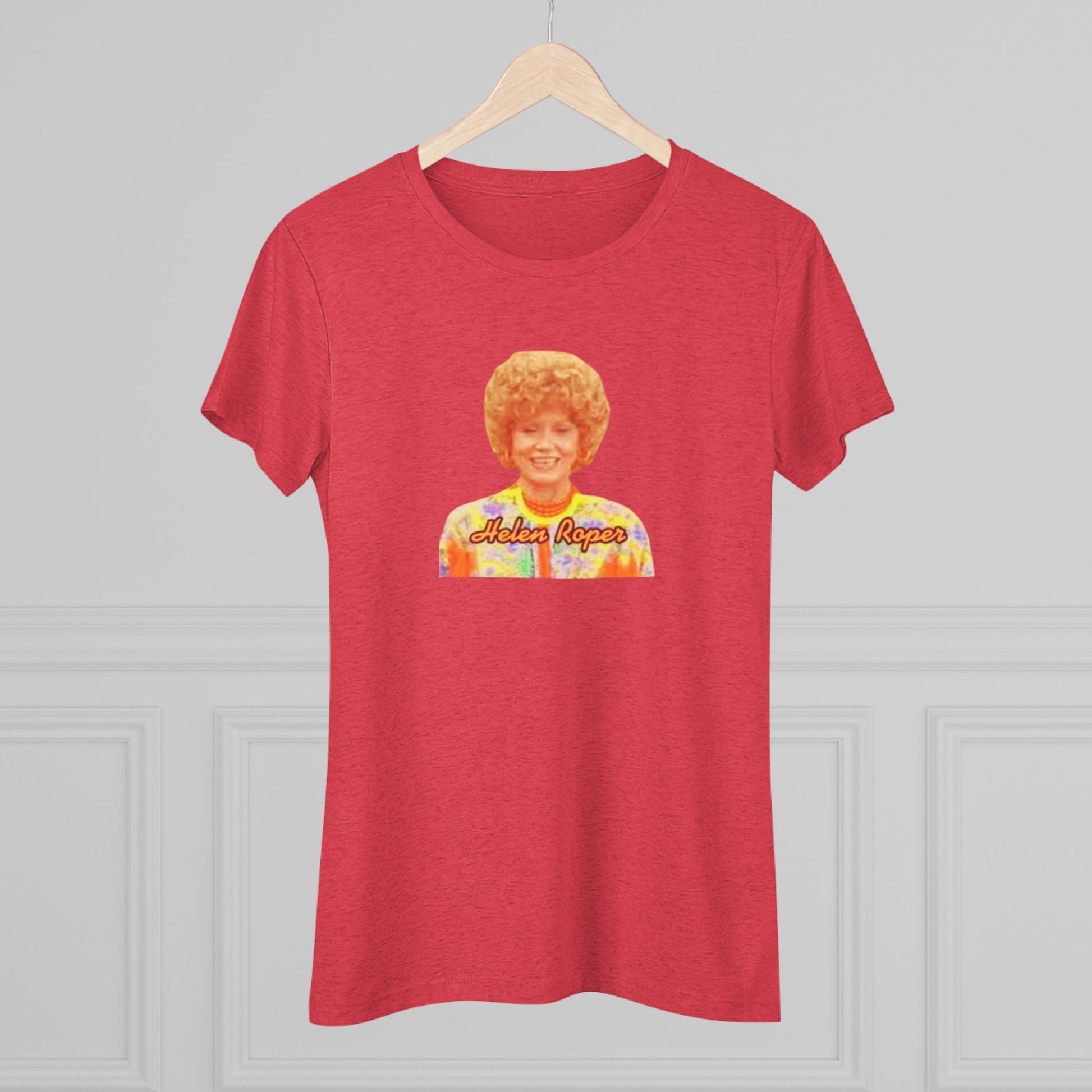 A Women's Triblend Tee by Printify, titled "Helen Roper - Three's Company," features a red design with an illustration of a smiling person with curly hair and colorful clothing. Below the illustration, the text "Helen Roper" is written in a bold, retro font, capturing the essence of vintage TV humor.