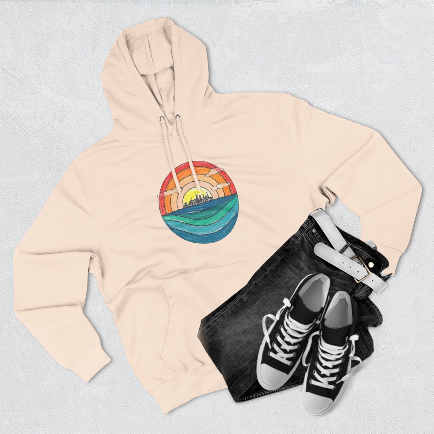 The Miller Beach Abstract - Three-Panel Fleece Hoodie by Printify is a premium light gray pullover featuring a vibrant circular front design. It showcases an abstract sunset-over-ocean scene with blue waters, an orange to red gradient sky, and a city skyline silhouette. Made from soft combed ring-spun cotton and lined with cozy fleece for extra warmth.