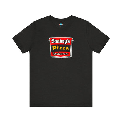 A black Shakey's Pizza - 1980s Retro Logo - Unisex T-Shirt by Printify hangs against a white background. The shirt features a colorful graphic with the text "Shakey's Pizza Restaurant" in white, yellow, and black lettering on a red background, resembling vintage pizza joints signage. This retro tee brings nostalgic vibes of classic pizzerias.