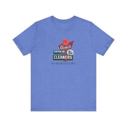 A unisex Jersey short sleeve tee from Printify featuring a light grey color with a retro-style graphic in the center. The design showcases text that reads "Gene's Drive In Cleaners, 5th," along with the address "12401 Vincennes Blue Island IL" in a blend of vintage fonts and colors, evoking the classic Chicago Fire-era vintage sign aesthetic.