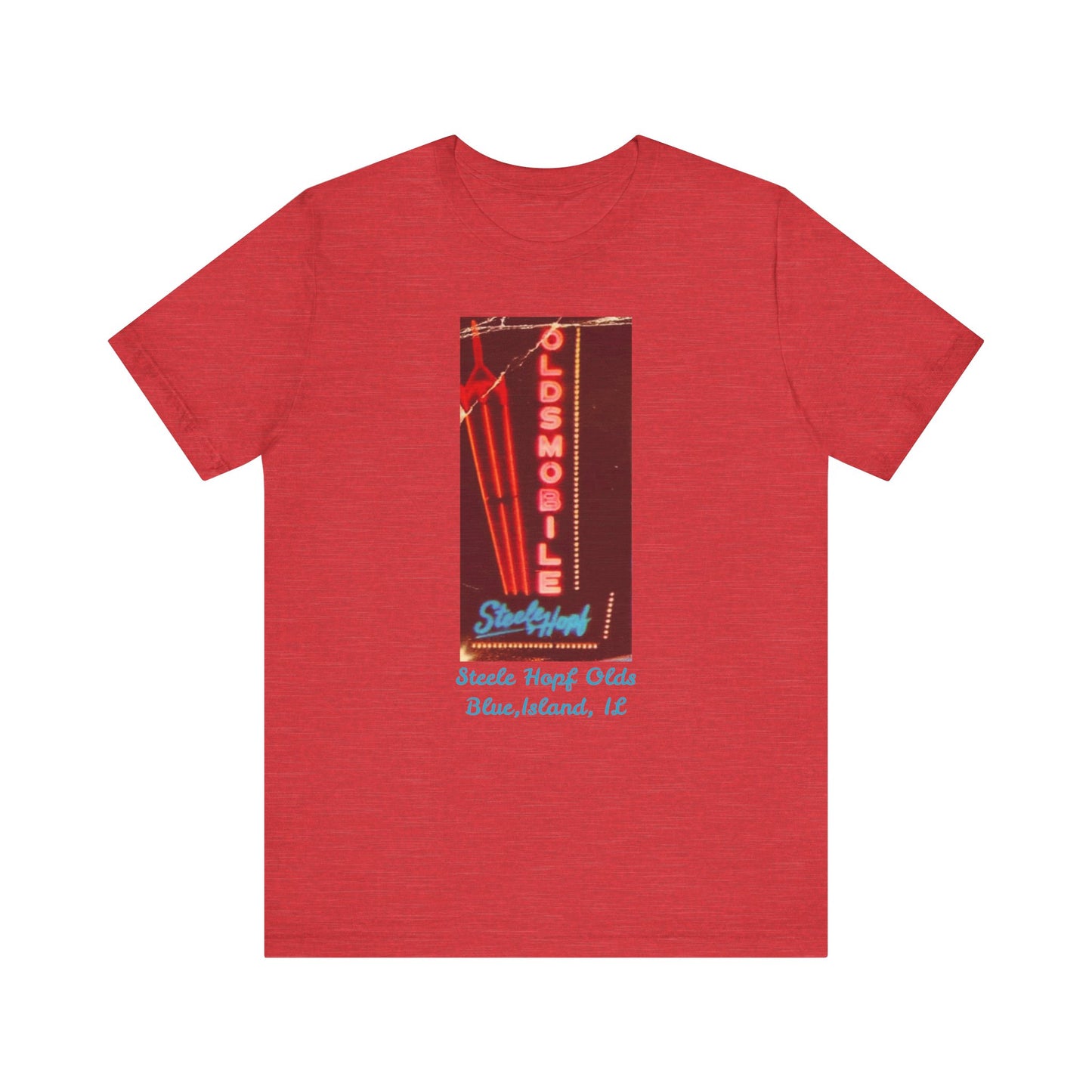 The Blue Island Illinois Steele-Hopf Oldsmobile Unisex Jersey Short Sleeve Tee by Printify features a vibrant red design with an image of a vintage neon sign. The sign displays "OLDSMOBILE" in vertical red letters and "Strafford" in blue cursive script. Below the sign, light blue text reads "Sleets Hopf Olds" and "Blue Island, IL," making it an ideal retro-inspired tee for classic car enthusiasts.