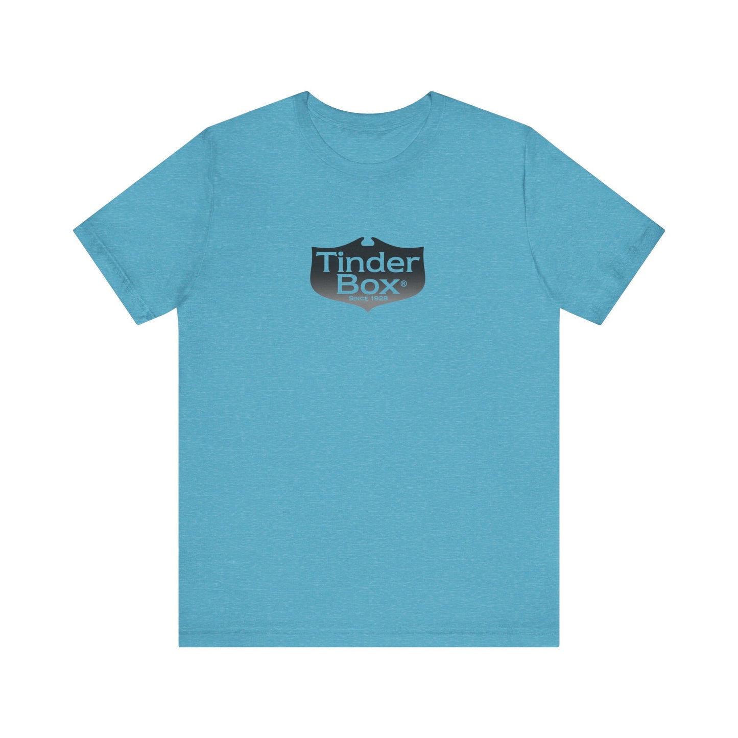 A light blue Printify "The Tinder Box 1980s" unisex jersey short sleeve tee featuring the "Tinder Box" logo in the center. The logo consists of a dark shield with the words "Tinder Box" in white text, with a small flame icon replacing the dot above the "i".
