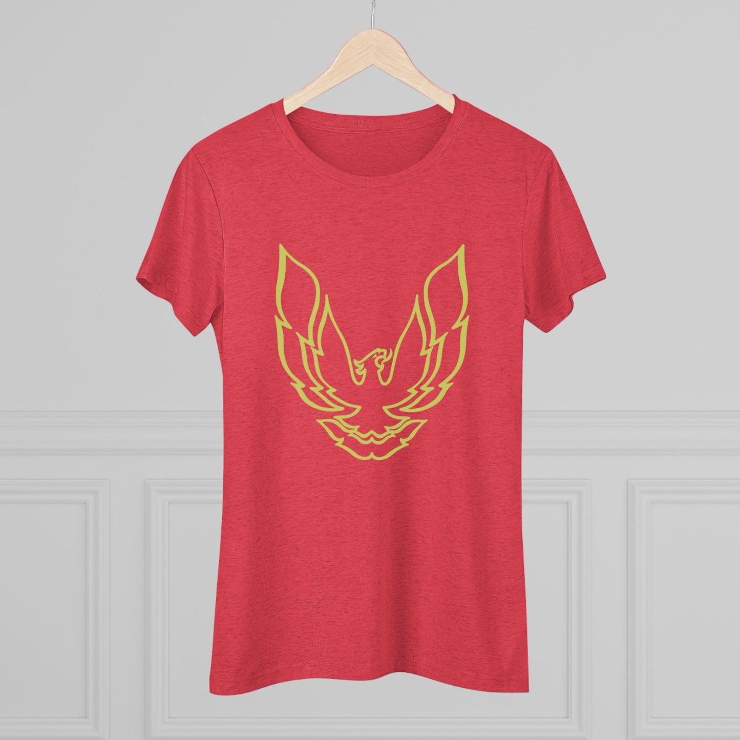 A retro 1970's-inspired red women's triblend tee by Printify, featuring a stylish gold phoenix design on the front. The vibrant, sleek graphic depicts the iconic Trans Am bird with its wings spread upward, giving this cozy t-shirt a bold and dynamic look.