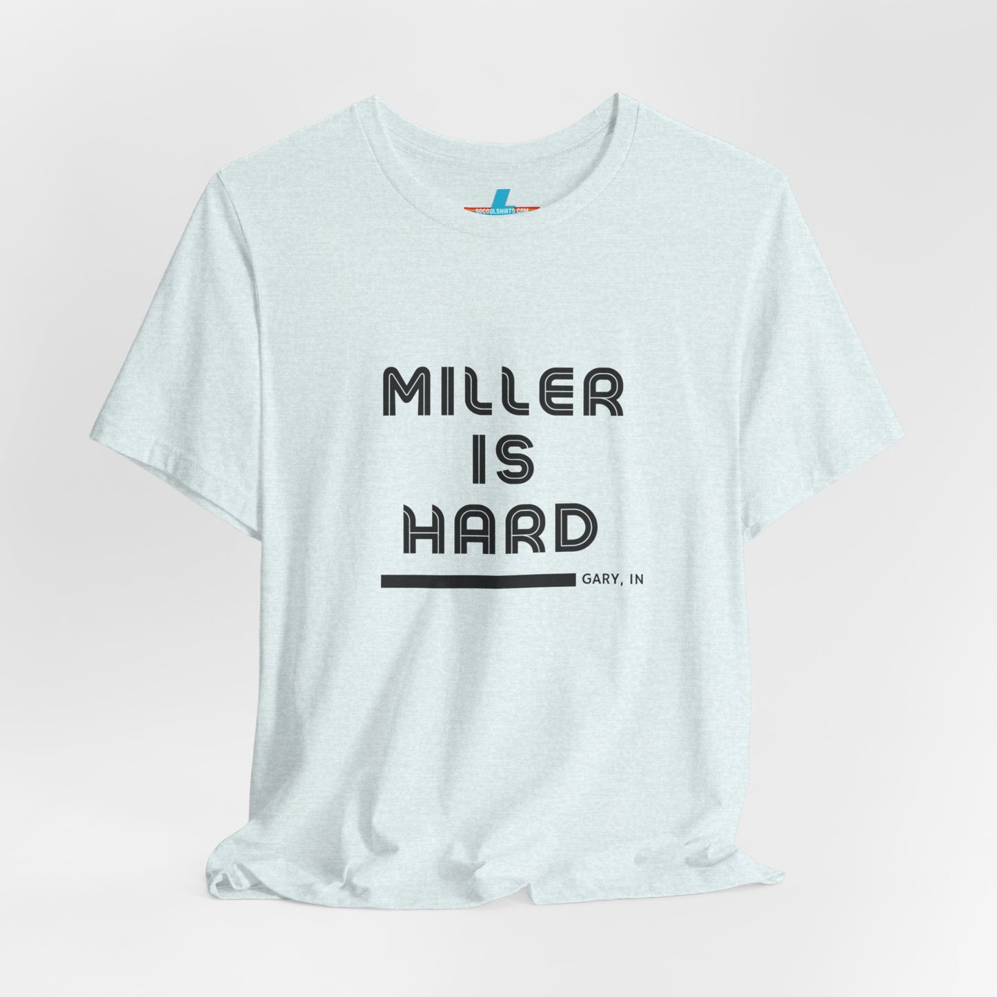 A unisex jersey short sleeve tee from Printify in burnt orange features the bold black text "MILLER IS HARD" on the chest, with "GARY, IN" written beneath in smaller black font. Perfect for showcasing Miller Beach's iconic spirit, this t-shirt is displayed against a plain white background.