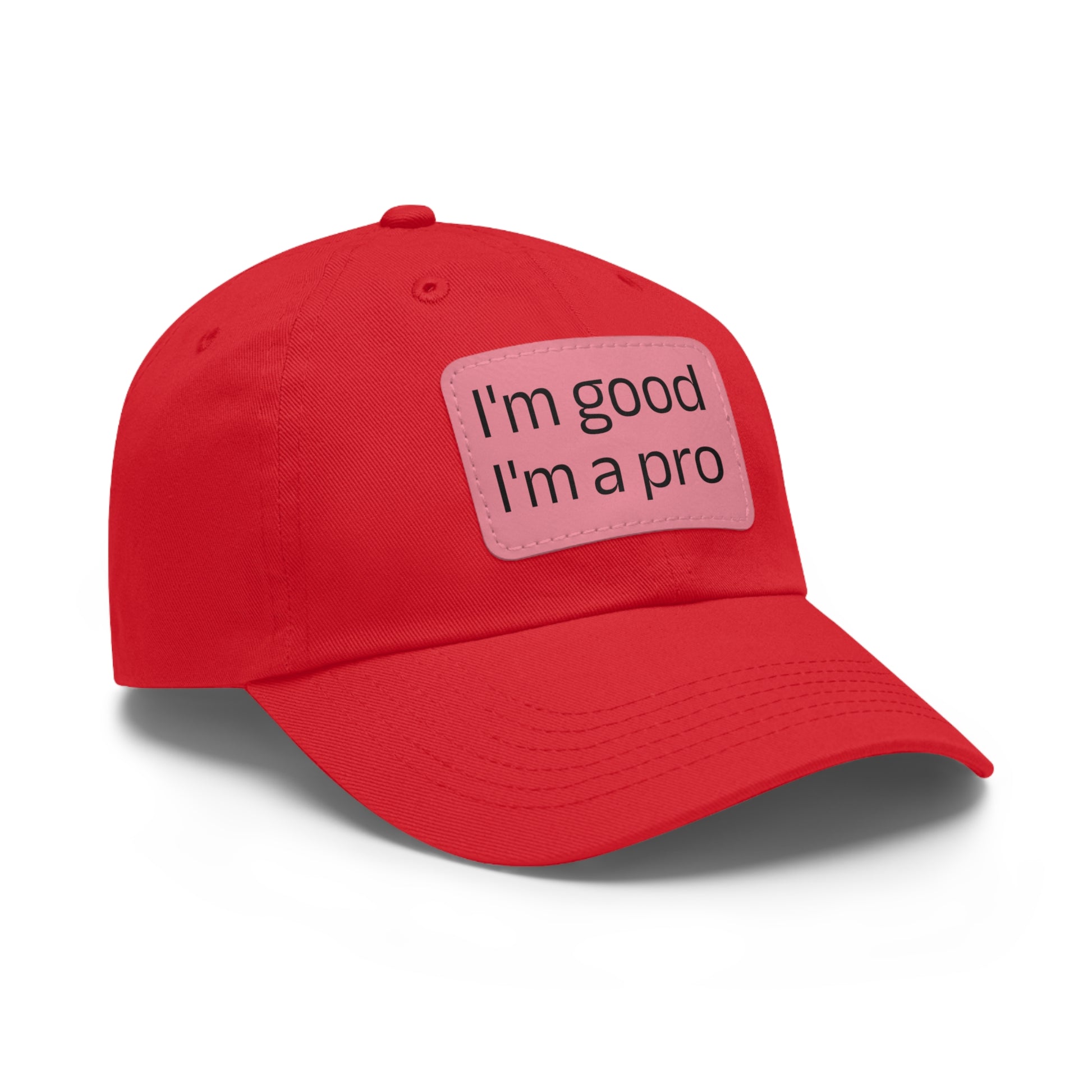 The Printify Dad Hat with Leather Patch (Rectangle) is a black, six-panel low-profile baseball cap made from bio-washed chino twill. This personalized Dad hat features a curved brim, visible stitching details, and a rectangular leather patch on the front that reads "I'm good I'm a pro" in grey text.