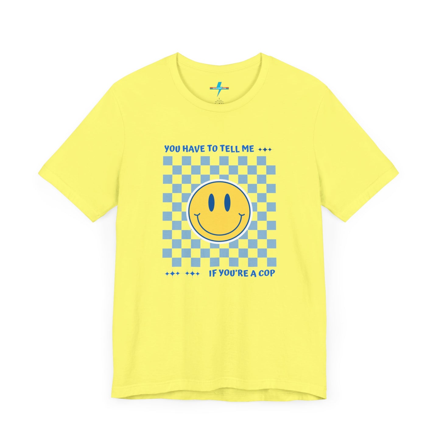 A light yellow unisex jersey short sleeve tee from Printify featuring a blue and yellow checkerboard pattern with a large yellow smiley face in the center. The shirt displays blue text above and below the pattern that reads, "You have to tell me if you're a cop." It's made from 100% Airlume combed and ring-spun cotton.