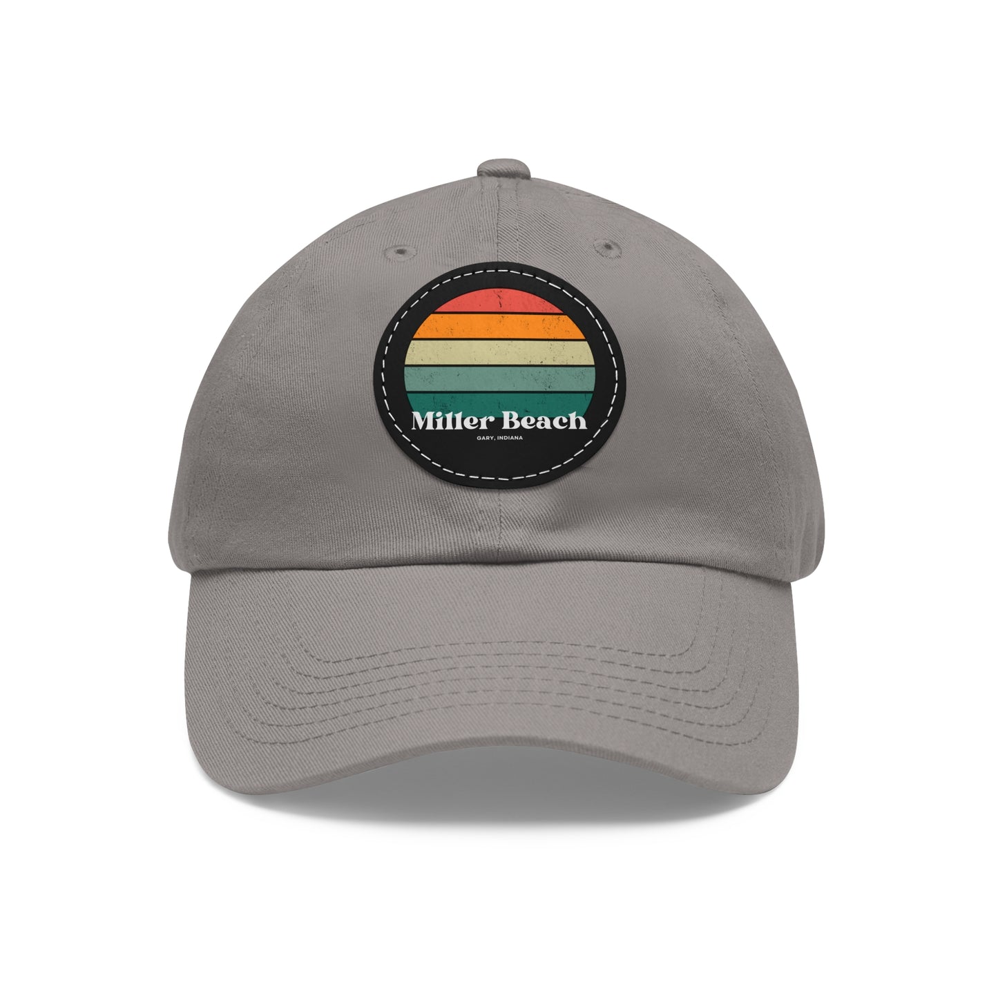 The Miller Beach Retro Sunset - Dad Hat with Leather Patch (Round) by Printify is a pink baseball cap crafted from bio-washed chino twill for added comfort. It features a PU leather patch adorned with horizontal stripes in red, orange, yellow, green, and blue. Below the stripes, "Miller Beach" is embroidered in white. An adjustable strap at the back ensures a perfect fit.