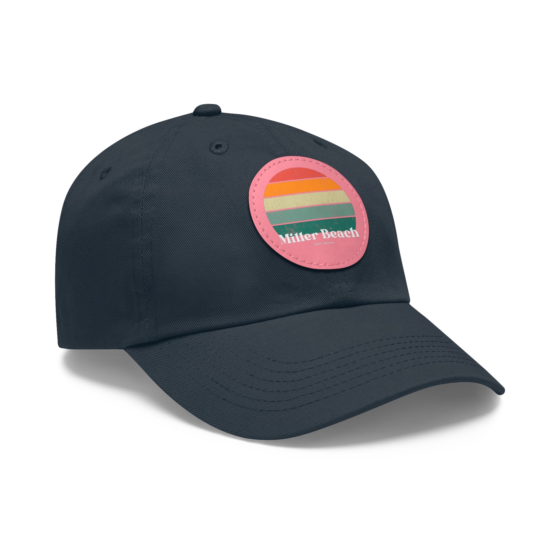 The Miller Beach Retro Sunset - Dad Hat with Leather Patch (Round) by Printify is a pink baseball cap crafted from bio-washed chino twill for added comfort. It features a PU leather patch adorned with horizontal stripes in red, orange, yellow, green, and blue. Below the stripes, "Miller Beach" is embroidered in white. An adjustable strap at the back ensures a perfect fit.