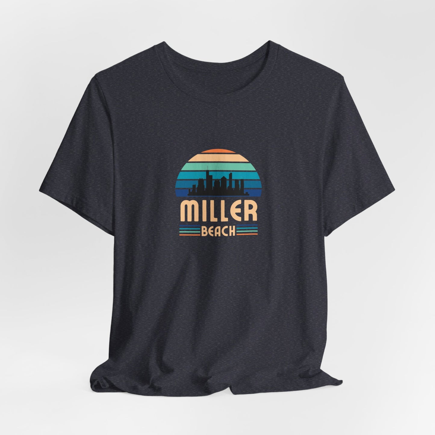 A brown unisex jersey short sleeve tee called "Miller Beach Chicago Skyline" from Printify features a vintage-style design with a sunset, the Chicago skyline, and "Miller Beach" in bold letters. The design incorporates shades of blue, orange, and yellow and is displayed against a plain white background.