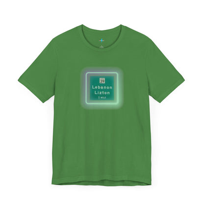 Introducing "The Lebanon Loop - Indiana" unisex jersey short sleeve tee by Printify. This green t-shirt features a graphic of a road sign displaying "39 Lebanon Lizton 1 MILE" within a slightly glowing square frame. It's crafted from 100% Airlume cotton and photographed flat on a white background.