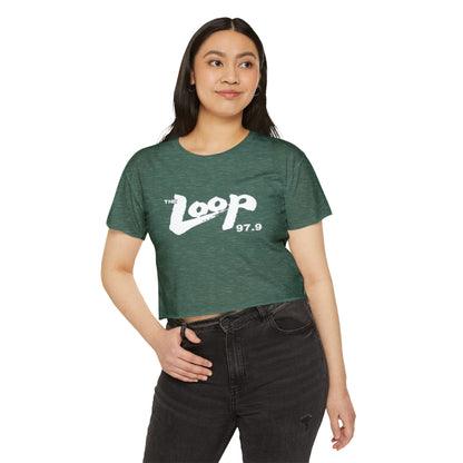 Printify's Women's Festival Crop Top features a grey design with short sleeves and a round neckline. The crop top displays the text "The Loop 97.9" in white, with the word "Loop" styled in a brushstroke-like font—ideal for fans of Chicago’s iconic rock radio station who appreciate retro fashion.