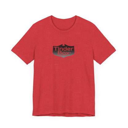 A light blue Printify "The Tinder Box 1980s" unisex jersey short sleeve tee featuring the "Tinder Box" logo in the center. The logo consists of a dark shield with the words "Tinder Box" in white text, with a small flame icon replacing the dot above the "i".