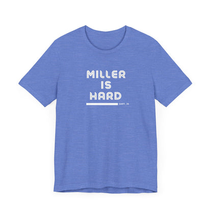 The Miller is Hard - White Letters - Unisex Jersey Short Sleeve Tee by Printify features a rust-colored design with "MILLER IS HARD" printed in bold, white capitals on the front. Below, "GARY, IN." is added in smaller font. This simple yet striking shirt evokes the spirit of Miller Beach with no additional graphics or patterns.