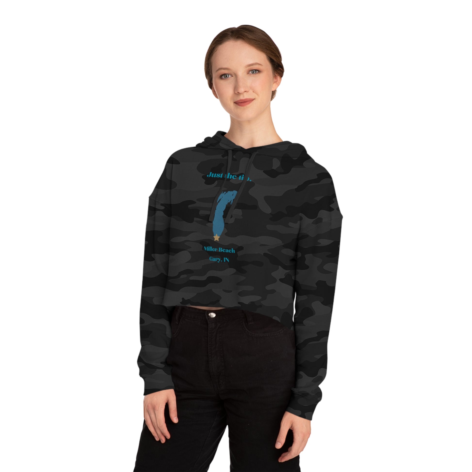 The "Just the Tip - Miller Beach - Women’s Cropped Hooded Sweatshirt" by Printify is designed in black camo with high-quality tri-blend fabric, showcasing a blue map shape and a yellow star. It features the phrase "Killer Beach" along with references to "Gary, IN," embodying the spirit of Miller Beach adventures.