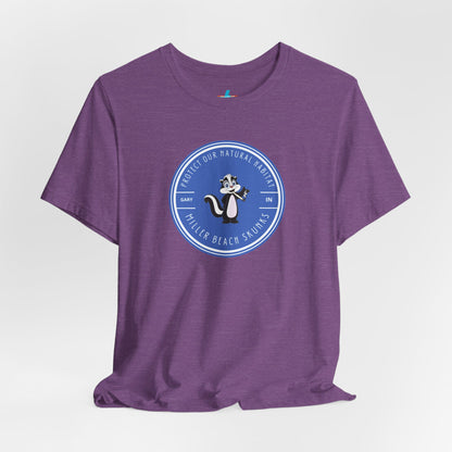 The Printify Miller Beach Skunks - Unisex Jersey Short Sleeve Tee is a gray T-shirt that features a circular blue logo at the center. Inside the logo, there is an illustration of a skunk with the text "Protect Our Habitat" and "Miller Beach Skunks" around the border, promoting environmental consciousness. The upper left part of the logo reads "Gary, IN.