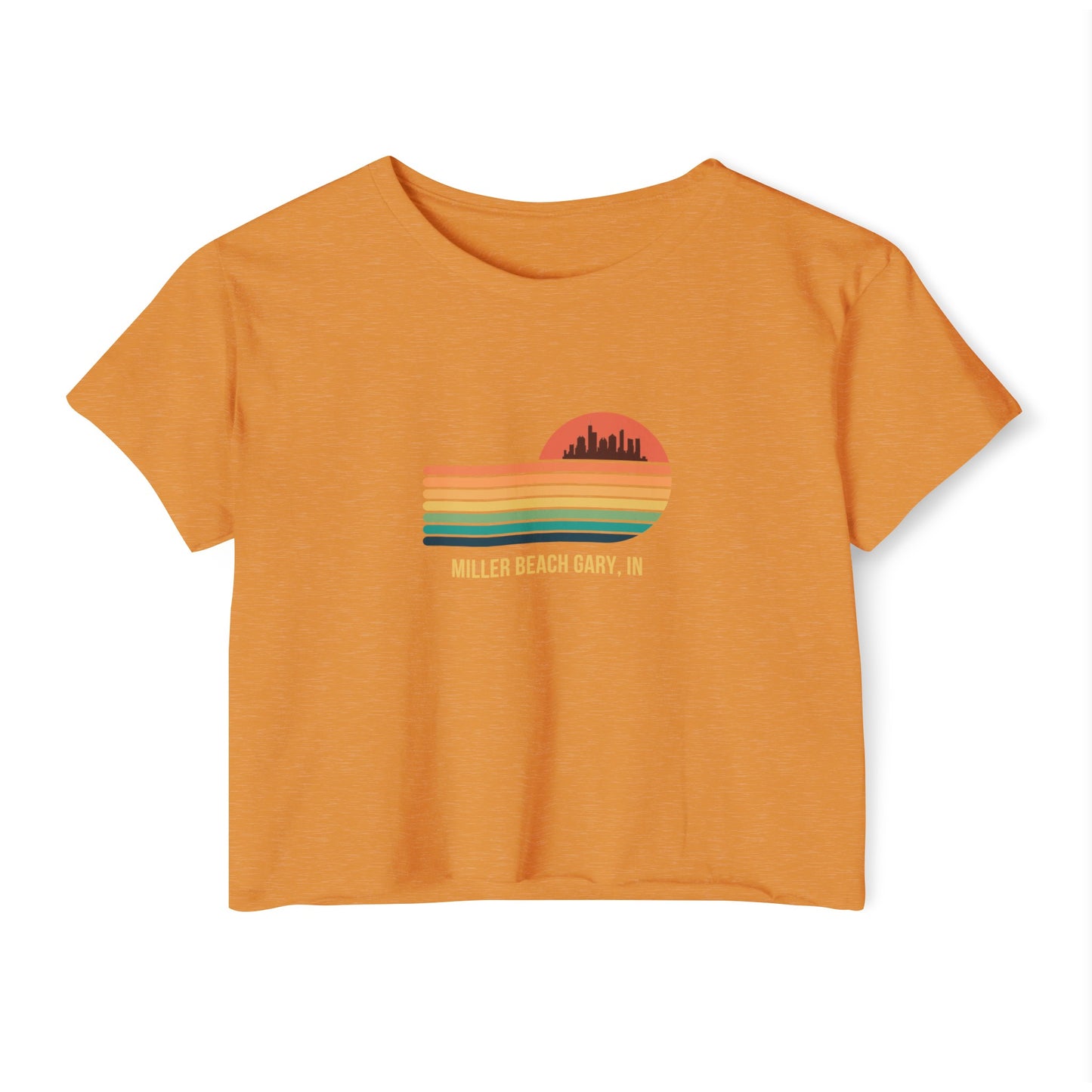 The Miller Beach Gary, IN Gradient Sunset - Women's Festival Crop Top by Printify is a mauve-colored T-shirt showcasing a retro-style graphic design of a sunset with multicolored stripes and a city skyline silhouette. Ideal for festival season, the text below reads "Miller Beach Gary, IN." Crafted to be soft and durable, this custom crop top provides both comfort and style throughout the day.