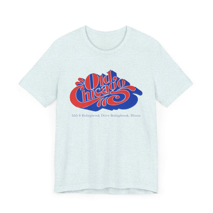 The "Old Chicago Mall Bolingbrook 1980s Retro - Unisex Jersey Short Sleeve Tee" from Printify is a gray T-shirt showcasing a vintage design with the text "Old Chicago" in blue and red. Beneath the main text, the address "355 S. Bolingbrook Drive, Bolingbrook, Illinois" appears in smaller font, evoking 80s nostalgia of the Old Chicago Mall. The shirt is displayed against a white background.