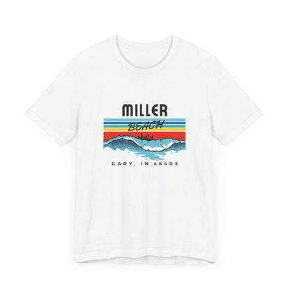 The Miller Beach 46403 Surf Style - Unisex Jersey Short Sleeve Tee by Printify features a retro surf-inspired design on a yellow background. The shirt displays "MILLER BEACH" above waves with a skyline illustration, while "Cary, IN 46403" is printed below the waves. The vibrant design also includes colorful stripes in shades of blue, red, and orange.