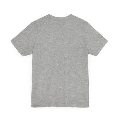 A light blue Printify "The Tinder Box 1980s" unisex jersey short sleeve tee featuring the "Tinder Box" logo in the center. The logo consists of a dark shield with the words "Tinder Box" in white text, with a small flame icon replacing the dot above the "i".