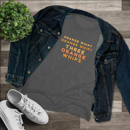 This Blues Brothers women's triblend tee from Printify features a dark gray vintage look with the text "ORANGE WHIP? ORANGE WHIP? THREE ORANGE WHIPS" printed in bright orange and yellow in the center. With a round neck and short sleeves, it's perfect for that retro vibe.