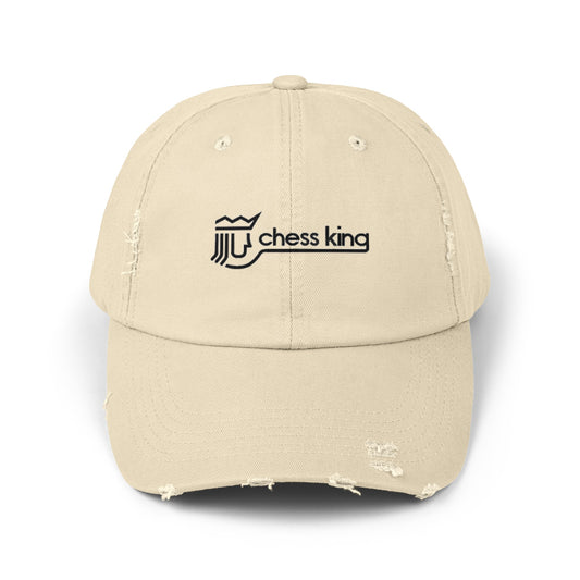 The 1980s Chess King Clothing Store Logo - Unisex Distressed Cap by Printify is a beige baseball cap made from 100% cotton twill. It features intentional distress details and a logo with a crown and rook piece, along with the text "chess king" embroidered on the front, making it a stylish choice for custom caps enthusiasts.