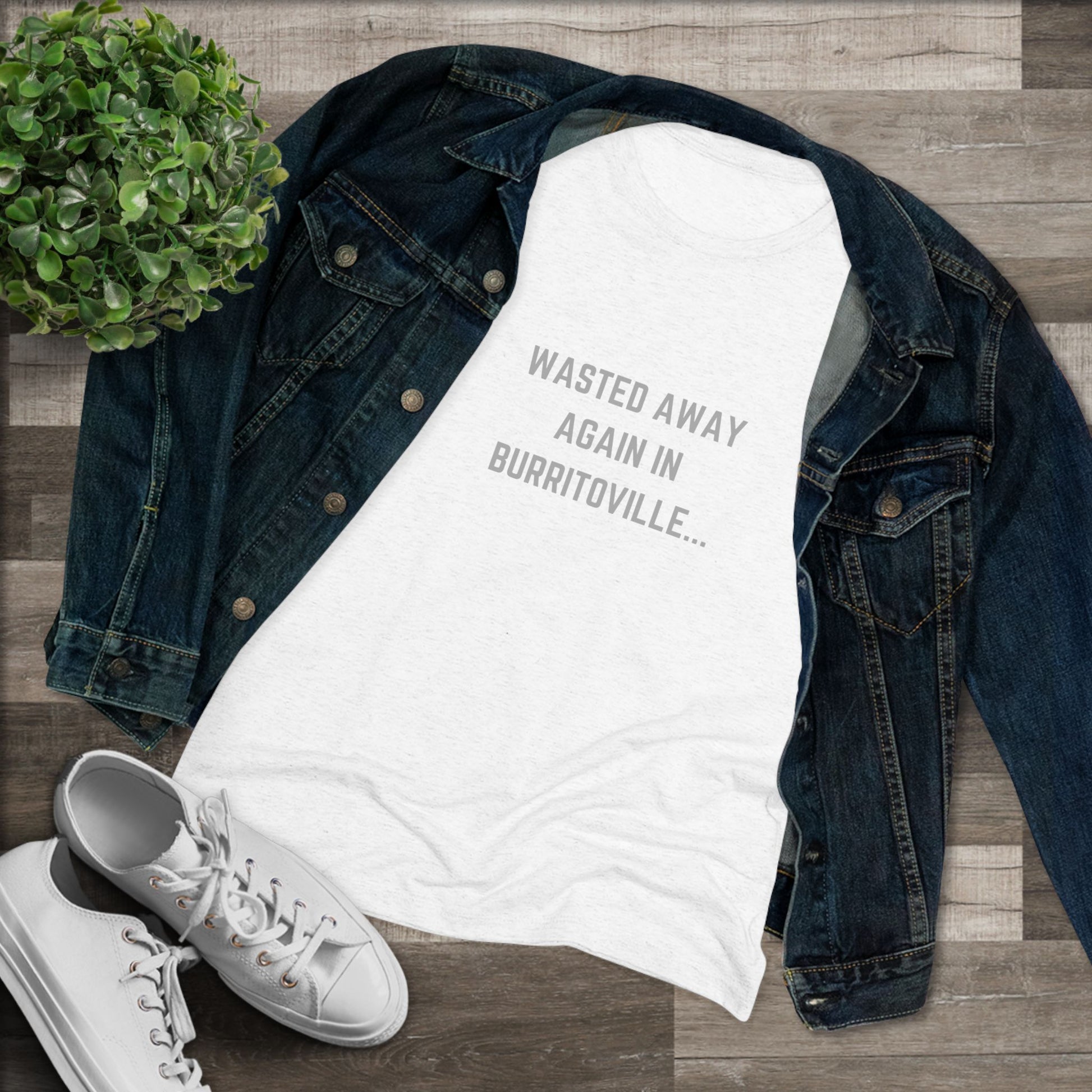 The Women's Triblend Tee from Printify, named "Wasted Away Again in Burritoville," is a dark gray heather vintage t-shirt featuring short sleeves and a crew neck. The front showcases the text "WASTED AWAY AGAIN IN BURRITOVILLE..." printed in white capital letters. This nostalgic piece from the 1980s is neatly displayed on a flat surface against a white background.