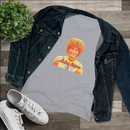 A Women's Triblend Tee by Printify, titled "Helen Roper - Three's Company," features a red design with an illustration of a smiling person with curly hair and colorful clothing. Below the illustration, the text "Helen Roper" is written in a bold, retro font, capturing the essence of vintage TV humor.