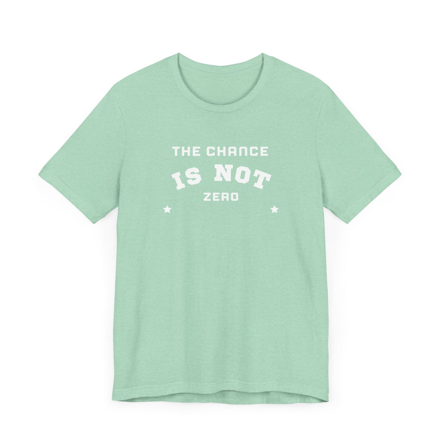 Folded light red Unisex Jersey Short Sleeve Tee from Printify, featuring bold white text that reads "THE CHANCE IS NOT ZERO" along with two star illustrations. This motivational T-shirt, made from breathable fabric, is neatly stacked with another identical shirt underneath.